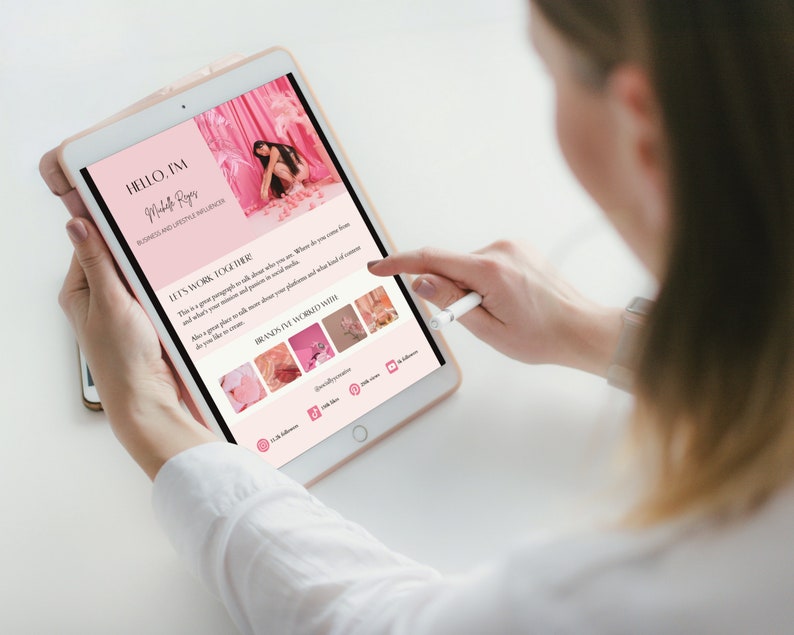 May include: A pink and white tablet screen displaying a website with the text "HELLO, I'M Madeline Reyes BUSINESS AND LIFESTYLE INFLUENCER LET'S WORK TOGETHER! This is a great paragraph to talk about who you are, where you come from and what's your mission and passion in social media. Also a great place to talk more about your platforms and what kind of content do you like to create. BRANDS I'VE WORKED WITH" and a grid of images.