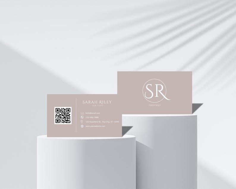 May include: A light brown business card with a QR code on the left side and text that reads "SARAH RILEY YOUR LIFE" on the right side. The other side of the card is light brown with a white circle containing the letters "SR" and the text "SARAH RILEY" below.
