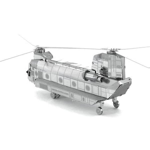 May include: A silver metal model of a Chinook helicopter. The model has detailed construction, including rotors, fuselage, and landing gear. The words "UNITED STATES ARMY" are visible on the side of the model.