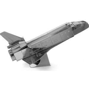 May include: A silver metal model of a space shuttle, with detailed wings, engines, and the text "UNITED STATES". The model is angled upwards and supported by a metal stand. The overall design is intricate.