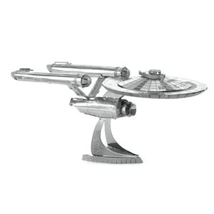 以下が含まれることがあります： スター・トレックのUSSエンタープライズ宇宙船の銀色の金属モデル。モデルは、船の象徴的な円盤セクション、ワープナセル、詳細なスタンドを備えています。モデルは、連動する金属片で作られています。