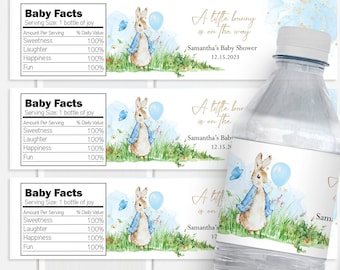 May include: Three clear plastic water bottles with labels featuring a watercolor illustration of a bunny rabbit holding a blue balloon. The labels also include the text "A little bunny is on the way", "Samantha's Baby Shower", and the date "12.15.2023".
