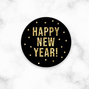 May include: Black circle with gold glitter text that reads "Happy New Year!" on a white marble background.