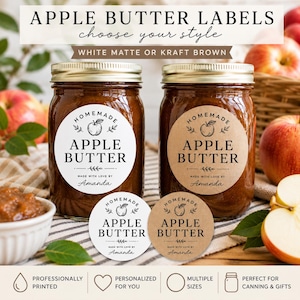 May include: Two glass jars filled with brown apple butter, each featuring a round label. One label is white and the other is kraft brown. Both display the text 'HOMEMADE APPLE BUTTER' and 'MADE WITH LOVE BY Amanda'. Two matching loose labels are placed in front.