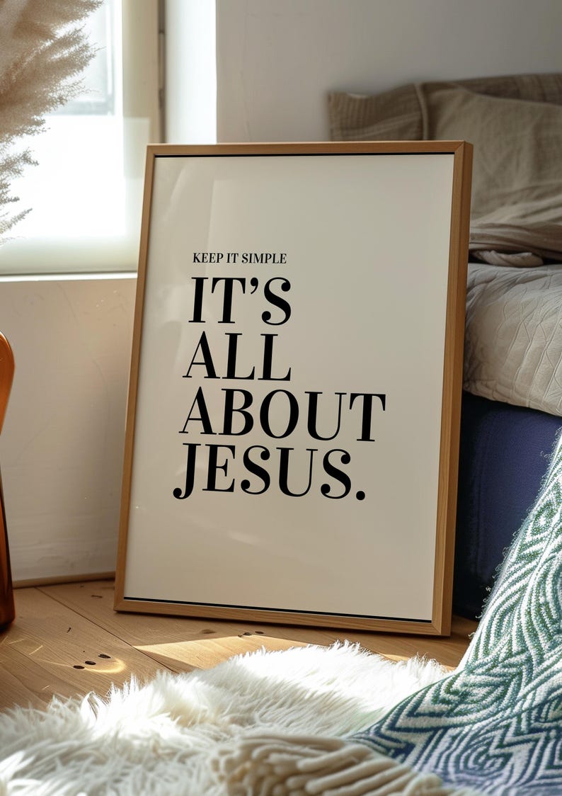 K&ouml;nnte beinhalten: Gerahmter Druck mit dem Text "KEEP IT SIMPLE IT'S ALL ABOUT JESUS." Der Druck hat einen cremefarbenen Hintergrund und schwarzen Text. Der Rahmen ist aus hellem Holz. Der Druck lehnt an einer Wand auf einem Holzboden.