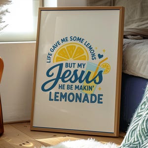 Pu&ograve; includere: Una stampa incorniciata con una cornice in legno chiaro. L'opera presenta il testo "LIFE GAVE ME SOME LEMONS BUT MY JESUS HE BE MAKIN' LEMONADE" in blu e giallo. Sono raffigurati anche una fetta di limone e un bicchiere di limonata.
