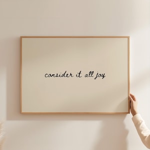 May include: A white ceramic mug with a black handle and the text "But First, Coffee" in a black, handwritten-style font. The mug is on a white surface.