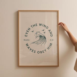 May include: Framed art print with a light beige background and a circular teal design featuring a wave and the text "EVEN THE WIND AND WAVES OBEY HIM MARK 4:41". The frame is a light brown color.