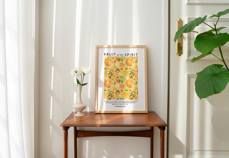 May include: A framed print with a yellow and orange floral pattern and the text "FRUIT of the SPIRIT" in black. The text below the floral pattern reads "But the fruit of the Spirit is love, joy, peace, longsuffering, gentleness, goodness, faith, meekness, temperance." and "GALATIANS 5:22-23".