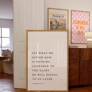 Könnte beinhalten: Drei gerahmte Kunstdrucke mit inspirierenden Zitaten und Kunstwerken. Ein Druck zeigt eine Landschaftsszene mit dem Text "Psalm 27". Ein weiterer Druck hat ein rosa-weißes Karomuster mit den Worten "Betrachte es als Freude". Der dritte Druck enthält den Text "Doch was wir jetzt erleiden, ist nichts im Vergleich zu der Herrlichkeit, die er uns später offenbaren wird Römer 8:18."