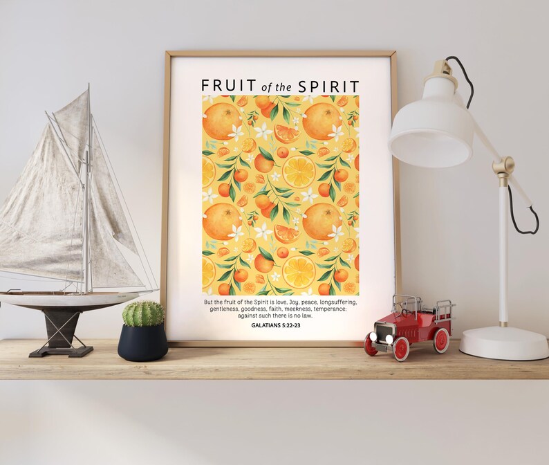 May include: A printable wall art print with a yellow background and a repeating pattern of oranges and white flowers. The text "FRUIT of the SPIRIT" is at the top of the print. The text below the pattern reads "But the fruit of the Spirit is love, joy, peace, longsuffering, gentleness, goodness, faith, meekness, temperance against such there is no law GALATIANS 5:22-23".