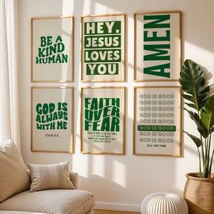 May include: Six framed art prints with inspirational quotes in green text on a cream background. The quotes include "Be a Kind Human," "Hey Jesus Loves You," and "God is Always With Me." The frames are a light wood color.