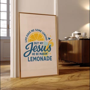 Pu&ograve; includere: Stampa artistica incorniciata con bordo dorato. L'opera presenta il testo "Life gave me some lemons but my Jesus he be makin' lemonade" in blu e giallo. Sono raffigurati anche una fetta di limone e un bicchiere di limonata.