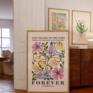 Könnte beinhalten: Ein beiger Poster mit einem floralen Design in den Farben Rosa, Lila, Gelb und Grün. Der Poster trägt den Text "Give thanks to the Lord for he is good, his love endures forever" und "Psalm 136:1".