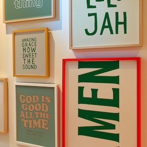 Op de afbeelding: Een verzameling ingelijste kunstafdrukken met inspirerende citaten. De prints tonen zinnen als "PRAY about every thing", "AMEN" en "GOD IS GOOD ALL THE TIME" in verschillende lettertypen en kleuren, waaronder groen, oranje en wit.