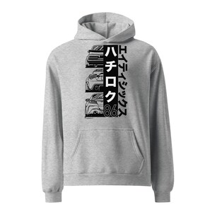 May include: A gray hooded sweatshirt with a black and white graphic print of three cars and the text "Toyota 86 Hachiroku".