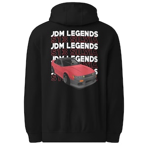 May include: Black hoodie with a red car graphic and the text "JDM LEGENDS S13 SILVIA" in white and red. The car is a red coupe with a black roof and grey accents. The design is repeated down the back of the hoodie.