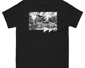 May include: A black short-sleeved t-shirt featuring a rectangular graphic print on the chest. The print depicts a grey sports car driving on a winding mountain road in a manga-style illustration with Japanese katakana sound effects.