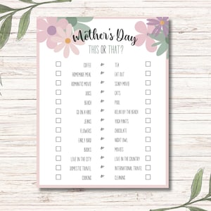May include: A printable Mother's Day game with a pink floral background. The game asks "This or That?" and includes a list of 14 questions with two choices for each question.  For example, "Coffee or Tea?" and "Homemade Meal or Eat Out?"