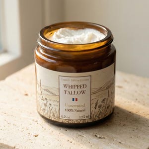 Puede incluir: Un tarro de vidrio marrón lleno de crema de sebo batida blanca. La etiqueta dice "French Tallow Cream, Whipped Tallow, Unscented, 100% Natural". El tarro contiene 125 ml de producto.