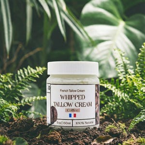 Puede incluir: Un tarro de Crema de Sebo Francesa, etiquetado como "Whipped Tallow Cream Coffee", con un gráfico de grano de café. El tarro es blanco con tapa blanca, y la etiqueta incluye la bandera francesa. El tarro es de 150 ml y 100% natural.