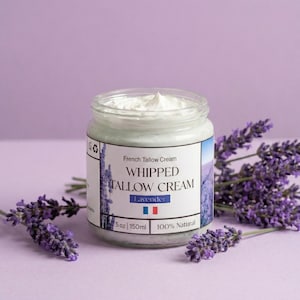 以下が含まれることがあります： 「Whipped Tallow Cream Lavender」とラベルされたフランスのタロークリームのガラス瓶。中には白いクリームが入っています。紫色の背景にラベンダーの小枝が添えられています。ラベルには150mlと記載されています。