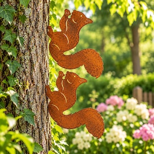 Peut inclure: Deux silhouettes d'écureuils en métal de couleur rouille conçues pour être fixées sur un arbre. Chaque figurine présente une finition texturée et patinée avec des détails découpés soulignant les oreilles, le visage et la queue touffue.