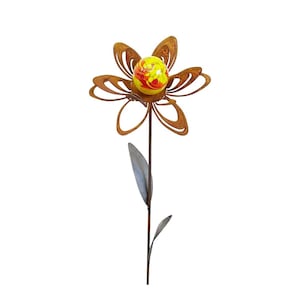 Könnte beinhalten: Eine rostige Metallblumen-Skulptur mit einer gelben und roten Glaskugel in der Mitte. Die Blume hat fünf Blütenblätter und einen Stiel mit zwei Blättern.