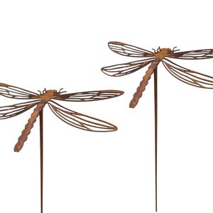 May include: Two rust-coloured metal dragonfly garden stakes. Each dragonfly features an intricate, open-work wing design with a segmented body and a long, thin metal rod extending downwards for placement in the ground or a planter.