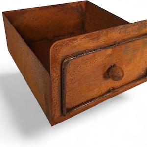 Pode incluir: Uma gaveta retangular de metal marrom enferrujado com a parte superior aberta e um puxador correspondente. A frente da gaveta tem um design emoldurado e um botão arredondado. O metal tem uma aparência texturizada e envelhecida.