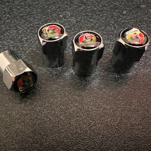 May include: Set of four chrome valve stem caps with a red, yellow and black logo.