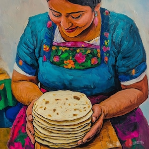May include: A woman wearing a blue and floral embroidered blouse holds a stack of freshly made tortillas. The tortillas are light brown and have a slightly rough texture.