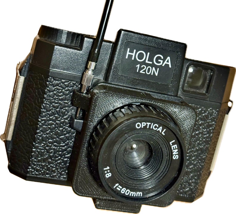 Image showing a shutter cable release adapter with a cable attached and in use to depress the shutter button.