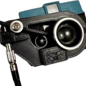 May include: A black 3D printed camera mount with a silver screw and a black strap. The mount is attached to a blue and black camera with a lens.