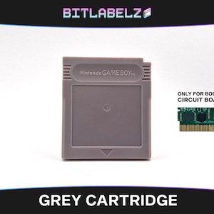 以下が含まれることがあります： 前面に「Nintendo GAME BOY」と印刷された灰色のゲームボーイカートリッジ。カートリッジは、海賊版回路基板用に設計されています。