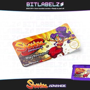 May include: A purple Game Boy Advance game cartridge with a colourful label featuring a cartoon character. The label reads "Shantae Advance" and "Risky Revolution!" with the WayForward logo.