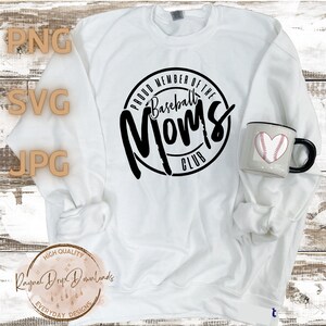 K&ouml;nnte beinhalten: Wei&szlig;er Pullover mit schwarzem Text, der "Proud Member of the Baseball Moms Club" lautet.