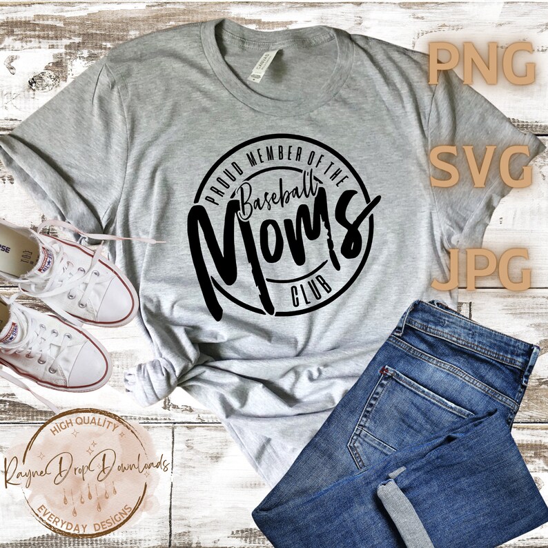 K&ouml;nnte beinhalten: Ein graues T-Shirt mit einem schwarzen Kreisdesign, auf dem "Proud Member of the Baseball Moms Club" steht.