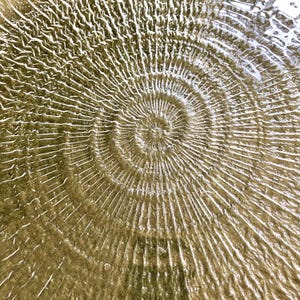 May include: A close-up of a swirling pattern in water, creating a ripple effect with concentric circles.