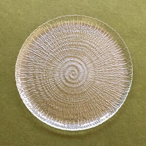 May include: A clear glass plate with a textured, concentric circle design.
