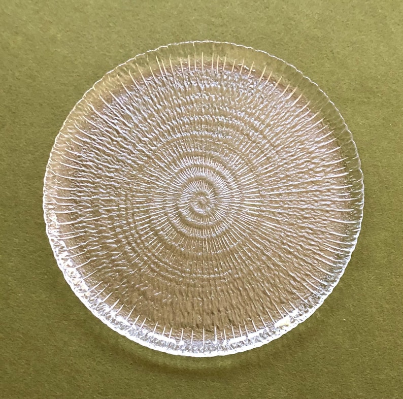 May include: A clear glass plate with a textured, concentric circle design.