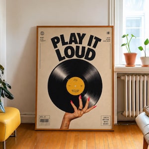 Könnte beinhalten: Ein gerahmtes Poster mit einer schwarzen Schallplatte, die von einer Hand mit roten Fingernägeln gehalten wird. Der Text lautet PLAY IT LOUD, MUSIC IS MY THERAPY, GOOD MUSIC GOOD LIFE und LIFE IS BETTER WITH MUSIC. Der Hintergrund ist hellbeige.