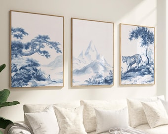 May include: Three framed wall art prints with gold frames. Each print displays a blue and white landscape design. The prints feature a mountain range, a tiger, and a tree with a person sitting under it.