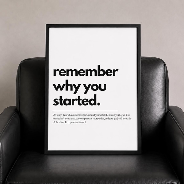 Puede incluir: Un cartel enmarcado con las palabras "remember why you started" en negrita negra. Debajo, un texto más pequeño dice: "On tough days...Keep pushing forward." El cartel está en un marco negro, sobre un fondo blanco, sobre una silla de cuero negro.