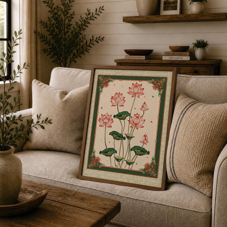 May include: A framed rectangular wall art piece featuring a botanical illustration of pink lotus flowers and green lily pads on a cream background, enclosed by a dark green border with small red floral accents at each of the four corners.