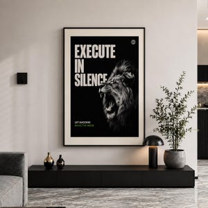 K&ouml;nnte beinhalten: A black framed poster with a roaring lion in black and white. The poster displays the words "EXECUTE IN SILENCE" in white, with "LET SUCCESS MAKE THE NOISE" below. A globe icon is in the top right corner.