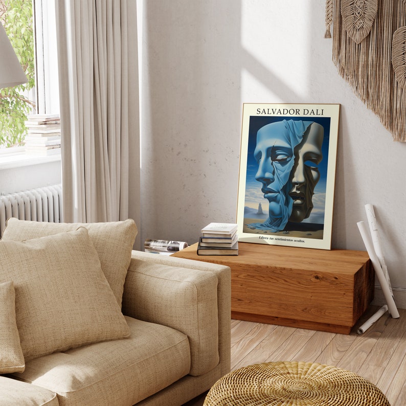 Op de afbeelding: Een poster met een surrealistisch schilderij van Salvador Dali. Het schilderij toont twee gezichten, waarvan er &eacute;&eacute;n gedeeltelijk bedekt is met een blauwe doek, tegen een woestijnlandschap. De poster is ingelijst in een cr&egrave;mekleurige lijst en heeft de tekst "SALVADOR DALI" bovenaan en "L'homme au sentiment obscure" onderaan.