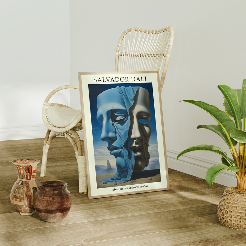 Op de afbeelding: Een ingelijste print van een surrealistisch schilderij van Salvador Dali met de titel "Libera tus sentimientos ocultos". Het schilderij toont twee gezichten, een blauw en een wit, met een blauwe doek eroverheen gedrapeerd. De achtergrond is een woestijnlandschap.