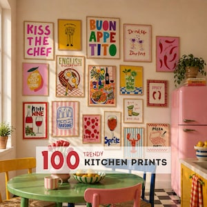 May include: A collection of framed kitchen prints with colorful illustrations and text, including phrases like "Kiss the Chef," "Buon Appetito," and "Pizza Party." The prints are displayed on a beige wall in a kitchen setting.