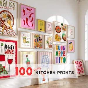 Może przedstawiać: Kolekcja oprawionych wydruków kuchennych z różnymi ilustracjami jedzenia i napojów. Wydruki przedstawiają kolorowe wzory, w tym papryczki chili, cytryny i tekst, taki jak "More Wine" i "Buon Appetito". Widoczny jest również tekst "100 Trendy Kitchen Prints".